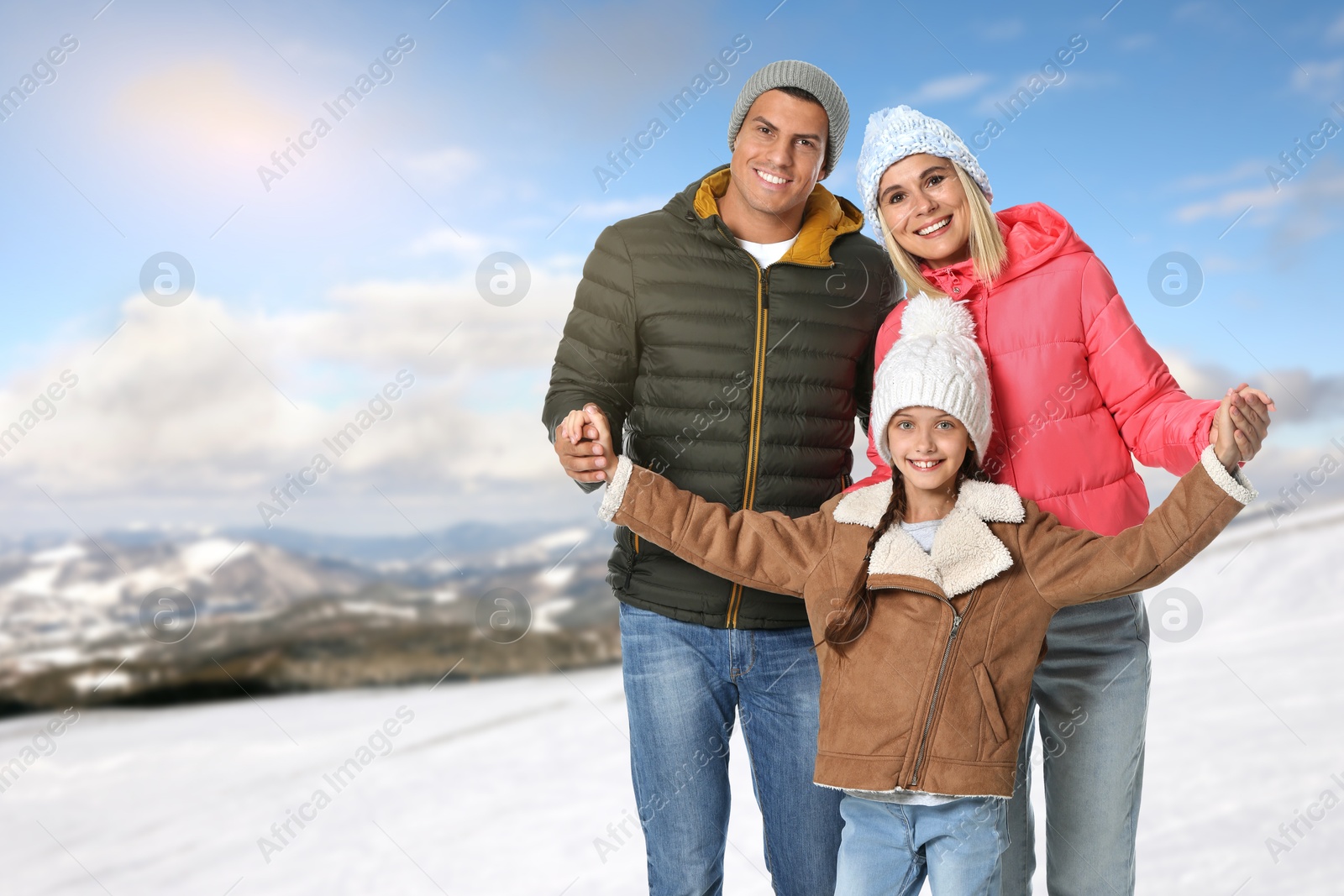 Image of Portrait of happy family with child in mountains on winter day