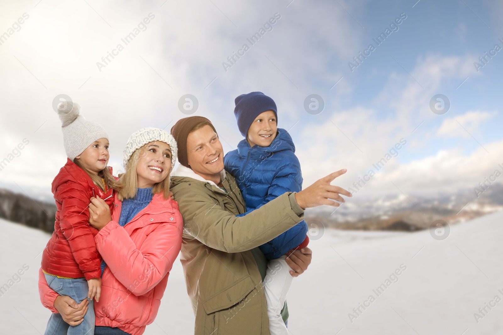 Image of Portrait of happy family with children in mountains on winter day