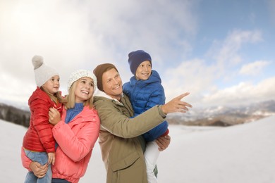 Portrait of happy family with children in mountains on winter day