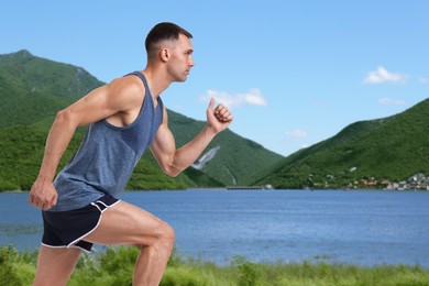 Image of Sporty man running on meadow near lake. Space for text