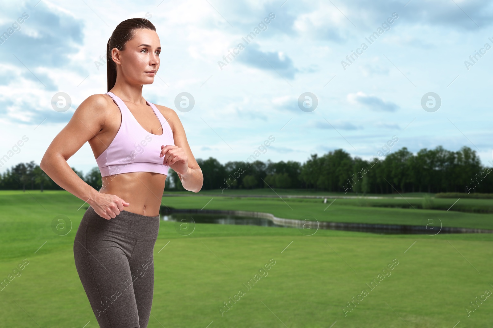 Image of Sporty woman running on meadow. Space for text