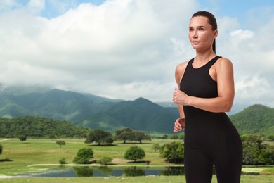 Sporty woman running on meadow near lake. Space for text