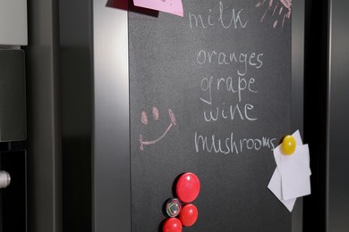 Magnetic board with shopping list and notes on refrigerator in kitchen