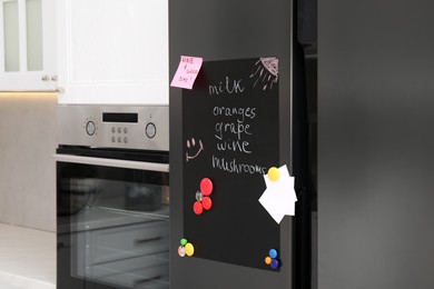 Magnetic board with shopping list and notes on refrigerator in kitchen