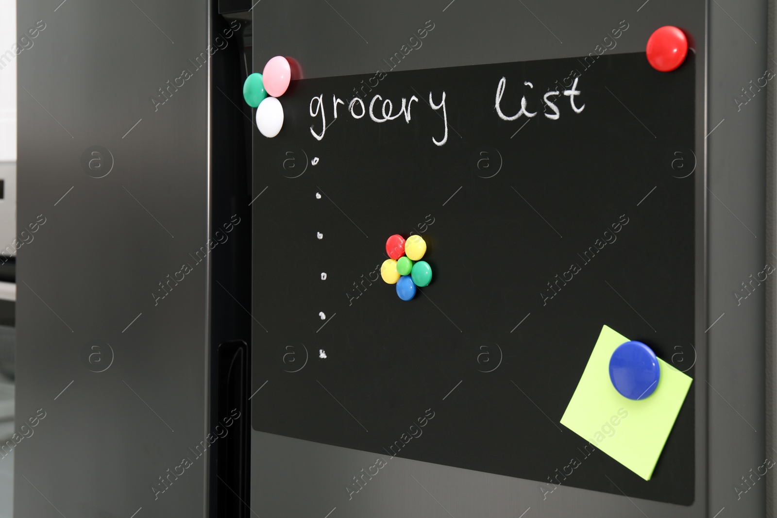 Photo of Magnetic board with grocery list and note on refrigerator in kitchen