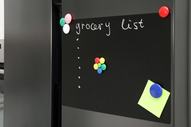 Magnetic board with grocery list and note on refrigerator in kitchen