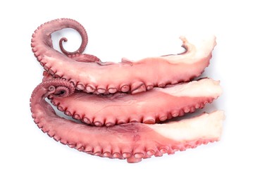 Photo of Three raw octopus tentacles isolated on white, top view