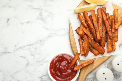 Photo of Delicious sweet potato fries with spices and sauce on white marble table, top view. Space for text