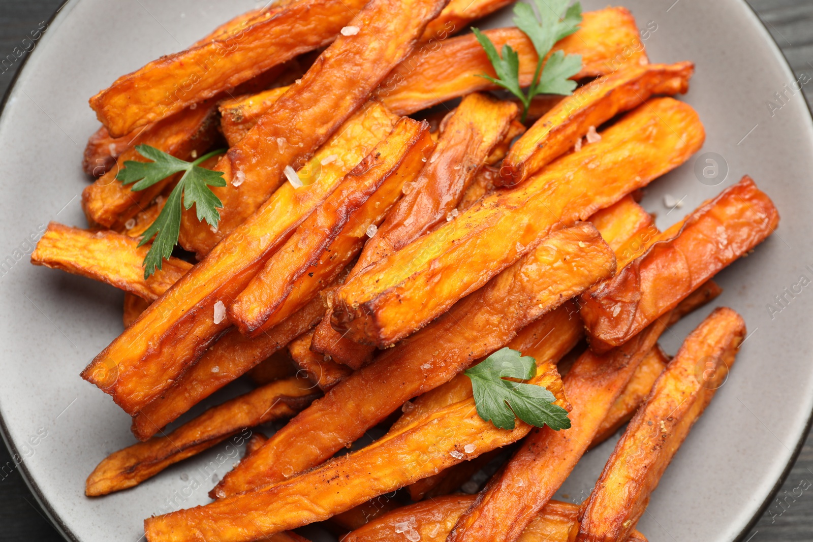 Photo of Delicious sweet potato fries with spices on table, top view