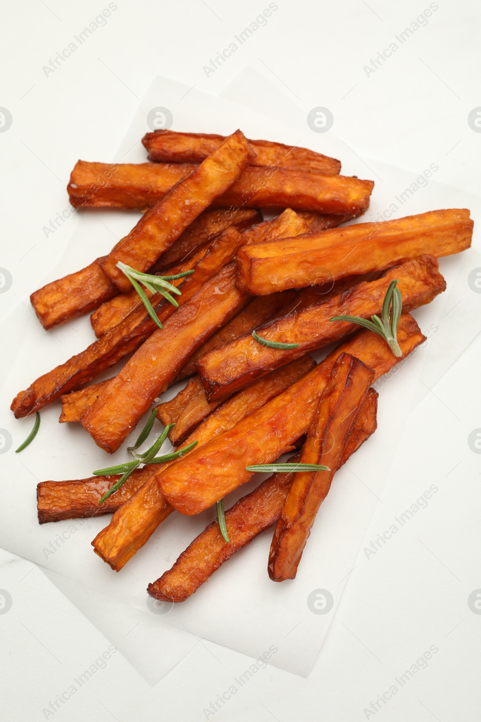 Photo of Delicious sweet potato fries with rosemary on white table, top view