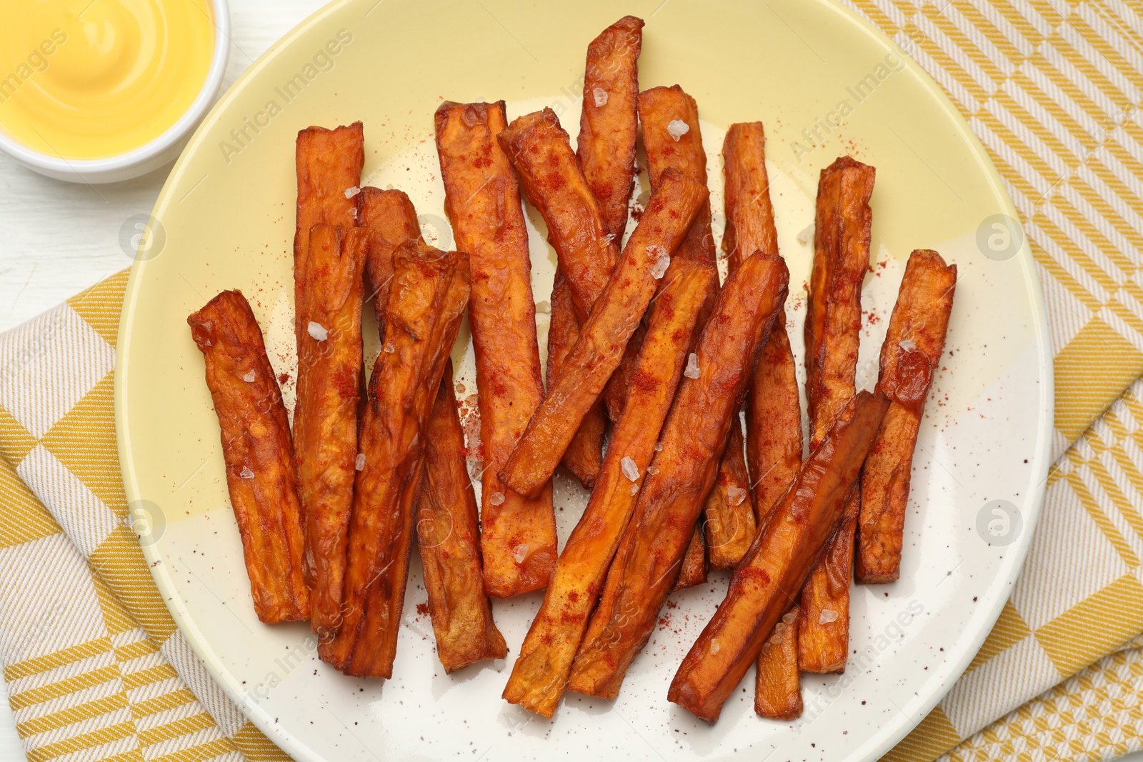 Photo of Delicious sweet potato fries and sauce on table, top view