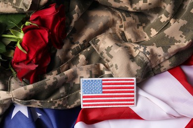 Photo of Veterans day. Army patch, military uniform and rose flowers on USA flag, closeup