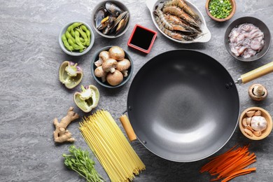 Different ingredients for wok on grey textured table, flat lay