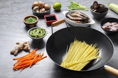 Different ingredients for wok on grey textured table