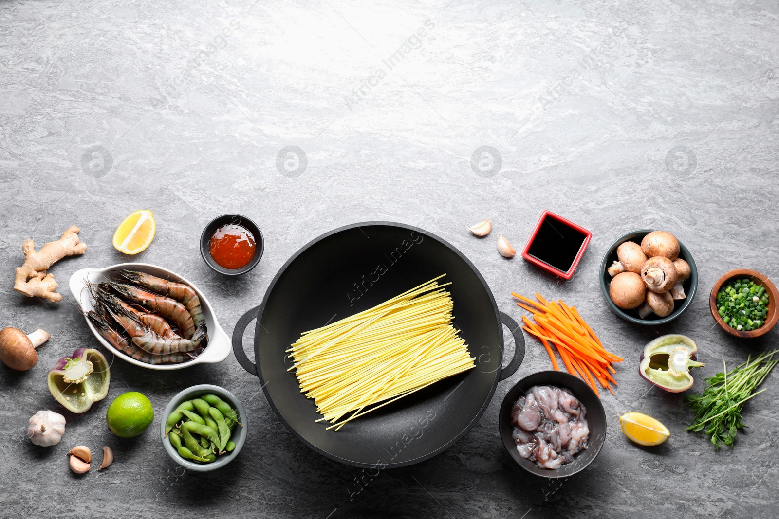 Photo of Different ingredients for wok on grey textured table, flat lay. Space for text