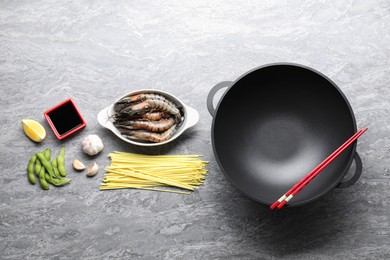 Photo of Different ingredients for wok on grey textured table, flat lay