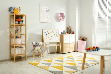 Photo of Beautiful child's room interior with toys and stylish furniture