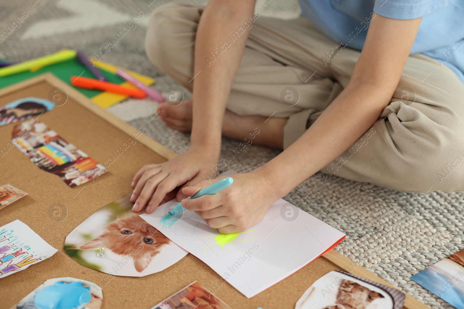 Photo of Creating vision board. Little boy drawing on paper indoors, closeup