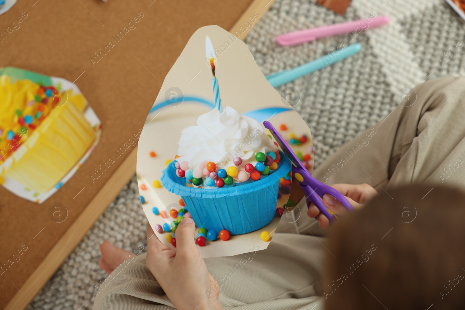 Photo of Creating vision board. Little boy cutting out picture indoors, above view