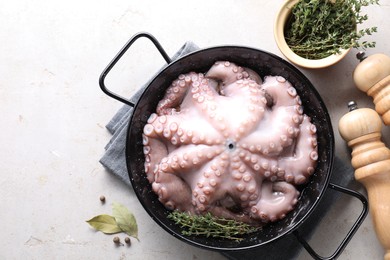 Fresh raw octopus and spices on grey table, top view