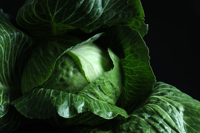 Photo of Whole ripe head of cabbage on dark background, closeup