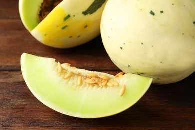 Photo of Fresh ripe honeydew melons on wooden table, closeup