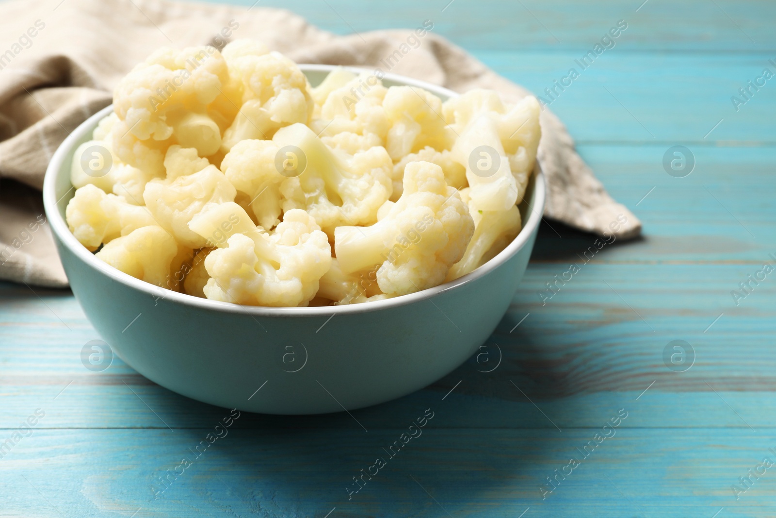 Photo of Tasty cooked cauliflower on light blue wooden table, closeup