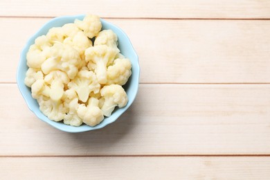 Photo of Tasty cooked cauliflower on white wooden table, top view. Space for text