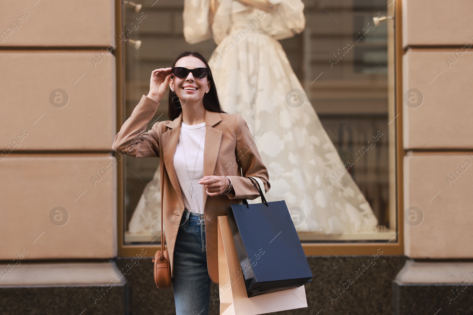 Photo of Happy woman with many shopping bags outdoors