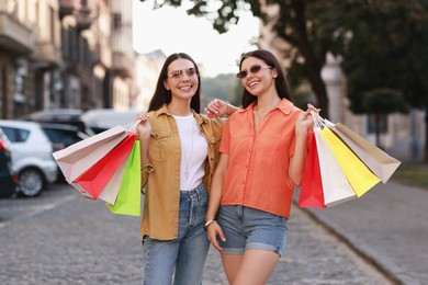 Happy women with colorful shopping bags outdoors