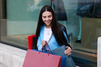 Happy woman with colorful shopping bags outdoors