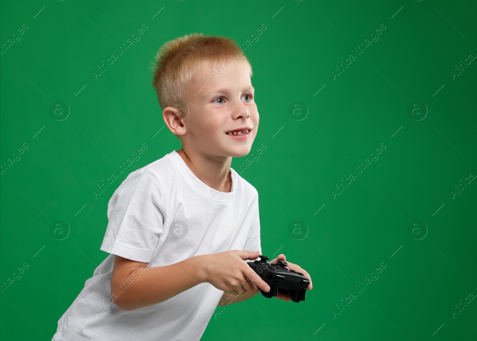 Photo of Happy little boy playing video game with controller on green background. Space for text