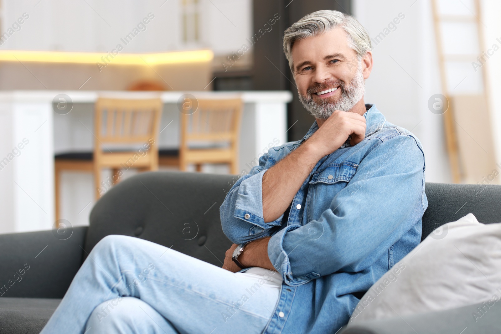 Photo of Happy middle aged man on sofa indoors