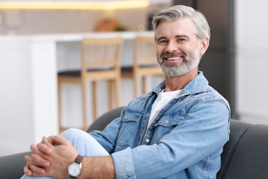 Happy middle aged man on sofa indoors