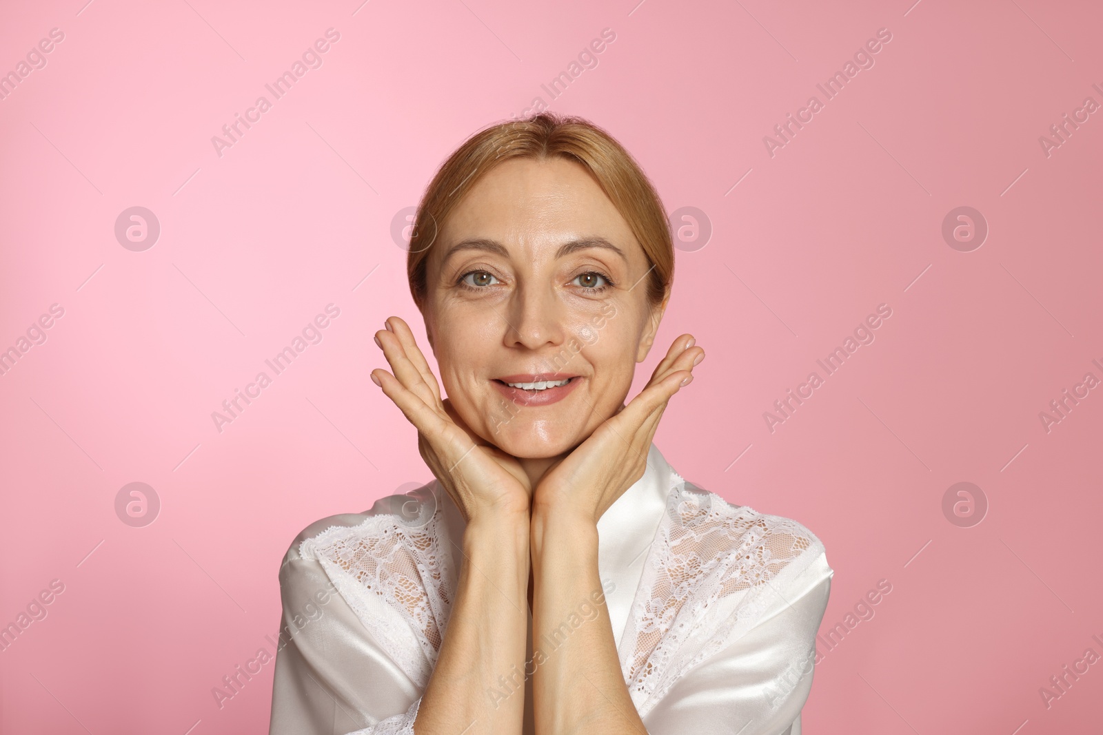 Photo of Portrait of smiling woman with healthy skin on pink background