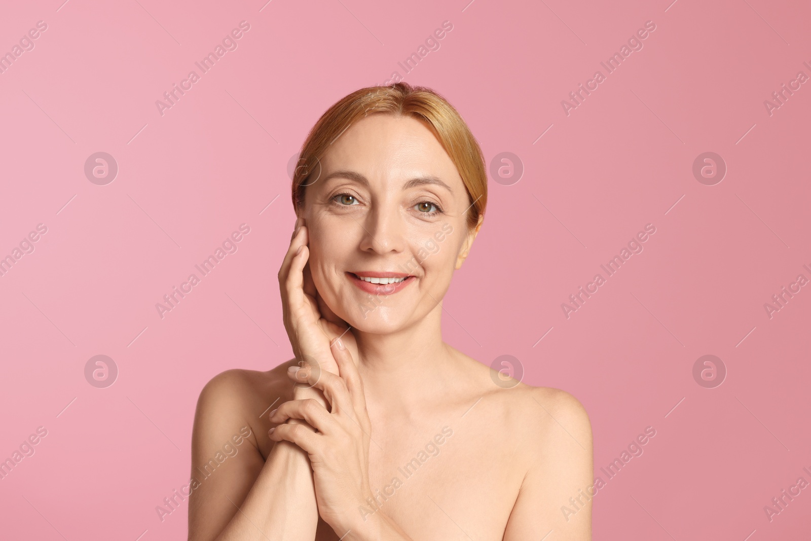 Photo of Portrait of smiling woman with healthy skin on pink background