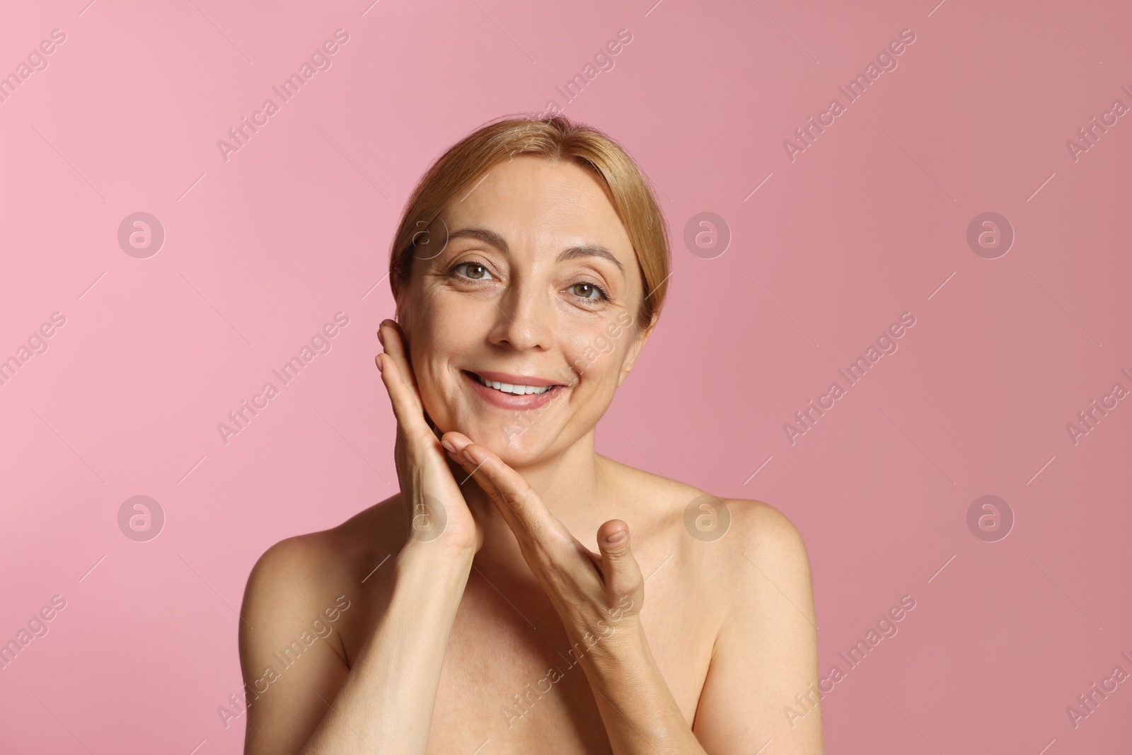 Photo of Portrait of smiling woman with healthy skin on pink background