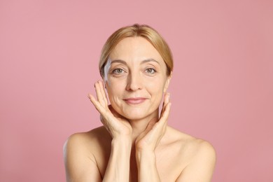 Portrait of beautiful woman with healthy skin on pink background