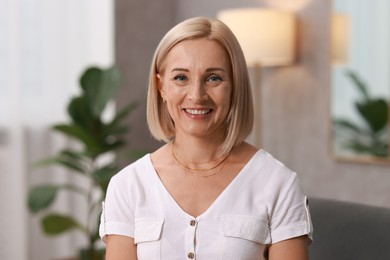 Photo of Portrait of smiling middle aged woman at home