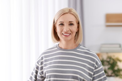 Photo of Portrait of smiling middle aged woman at home