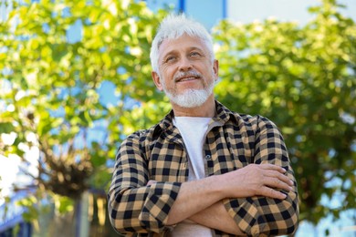 Smiling senior man outdoors, low angle view