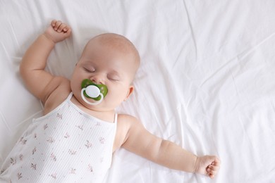 Photo of Cute little baby sleeping on bed at home, top view