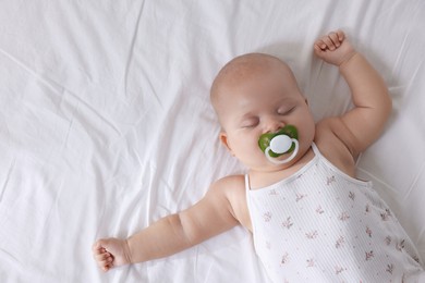 Photo of Cute little baby sleeping on bed at home, top view