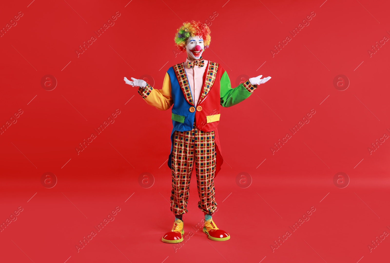 Photo of Portrait of happy clown on red background