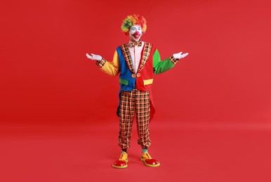 Portrait of happy clown on red background