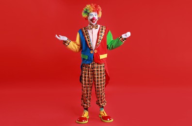 Portrait of happy clown on red background