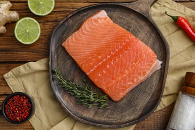 Photo of Salmon fillet, spices and lime on wooden table, flat lay