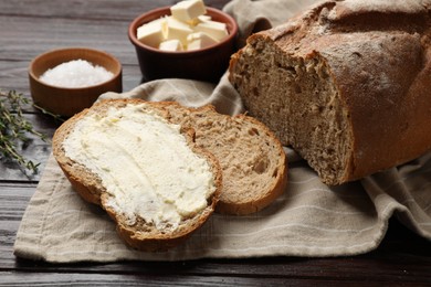 Photo of Fresh bread with butter on wooden table, closeup