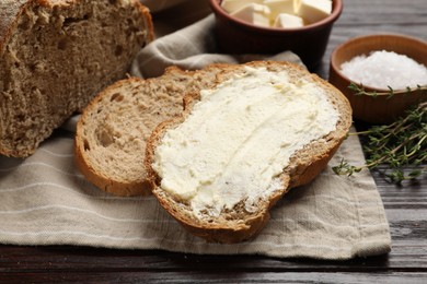 Photo of Fresh bread with butter on wooden table, closeup