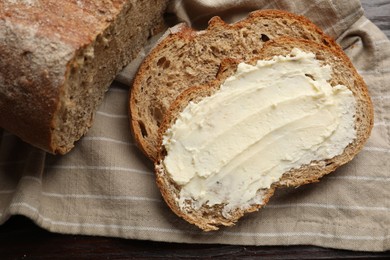 Photo of Fresh bread with butter on wooden table, top view